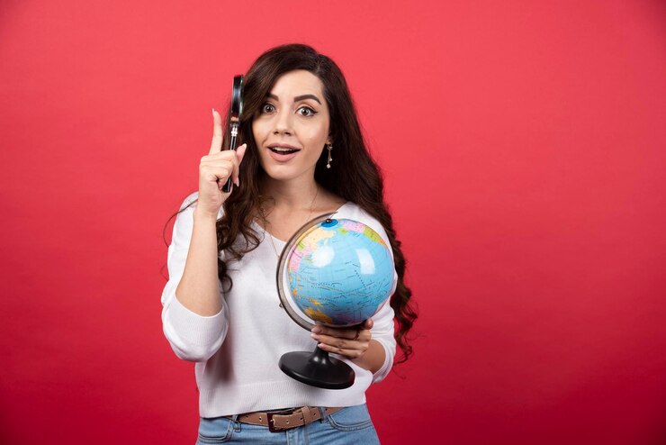 surprised woman posing with globe magnifying glass
